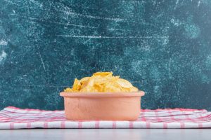 ceramic bowl delicious crunchy chips stone background