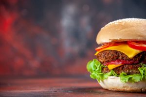 front view tasty meat burger with cheese salad dark background